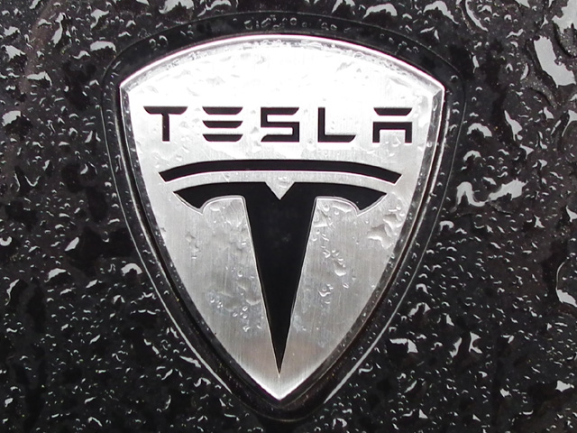 emblem of Tesla Motors with drizzles of water