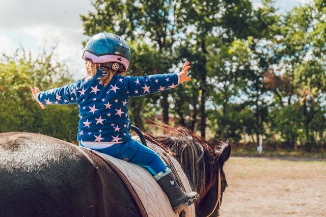 photo of a girl riding a horse