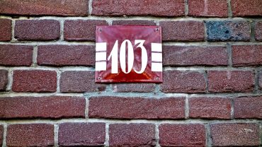 photo focused on plate with the number used to refer to the house made of brick